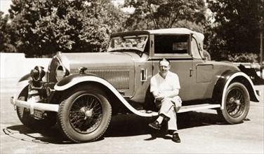 A 1928 Hotchkiss car. A European man poses beside a 1928 Hotchkiss car. The vehicle belonged to
