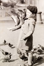 Feeding the pigeons. A British boy named Tim holds out his hand to feed the pigeons during a trip