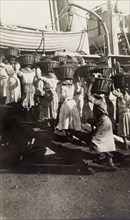 Women refueling a ship, Jamaica. A team of Jamaican women carry baskets of coal aboard a ship, as