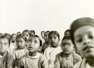 Indian schoolchildren. A class of Indian schoolchildren sit on the floor and listen attentively to