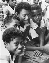 Fijian girls in uniform. Originally captioned "a mother with her small family", this portrait
