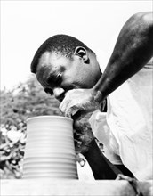 An Antiguan potter. An Antiguan potter skilfully turns a clay pot on a revolving wheel. Antigua,