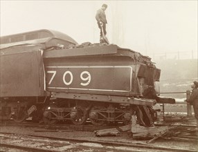 Train crash, Ontario. Railway workers inspect the damage caused to the rear of a steam locomotive