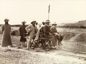 Rail cart on Kohat-Thal railway line. Three European men sit on a hand-operated rail cart on the
