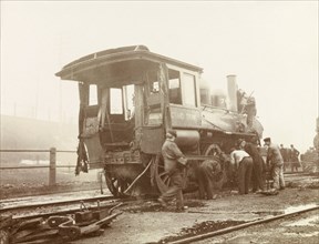 Repairing a steam locomotive, Canada. Railway workers attend to a steam locomotive after a railway