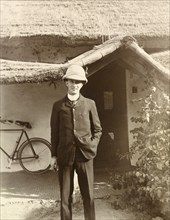 Man posing by thatched cottage, India. Portrait of a European man posing outside a thatched cottage