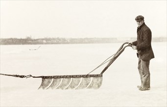 Cutting ice, Canada. An ice cutter steers a horse-drawn ice saw while removing ice from Lake