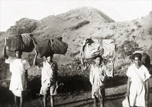 Indian porters in the Baba Budan Giri mountains. A team of Indian porters balance large bundles on