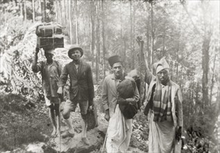 Evangelists trekking through forest, India. Methodist evangelists and Indian porters trek through a