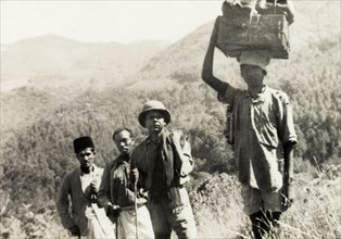 Evangelists trekking through mountain range. Methodist evangelists and Indian porters trek through