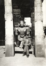 British Reverend visiting Chennakesava Temple. Reverend Norman Sargant poses beside a sculpture of