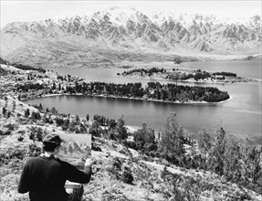 Painting Lake Wakatipu and the Remarkables. An artist puts the finishing touches to a painting of