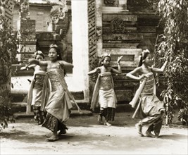 A traditional Balinese dance. Four Balinese women perform a dance outside a Hindu temple, dressed