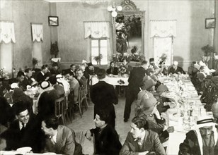 Arab officials attend a formal meal . A number of Palestinian Arab officials sit around long dining