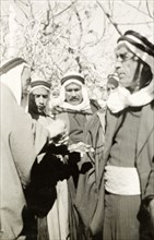 Arab villagers exchange money. Arab villagers wearing 'keffiyehs' (headdresses) exchange money