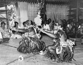 Dancing at a 'sevusevu' ceremony. Two Fijian men perform a dance with fans at a traditional