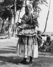 Fijian man with a 'tabua'. A Fijian man wearing face paint and ceremonial costume made from 'masi'