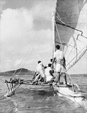 A 'drua' off the coast of Fiji. Four men crew a 'drua' (Fijian catamaran) off the coast of Fiji.