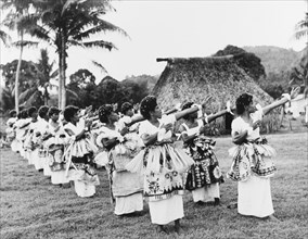 Fijian dancers at Nasilai. A large group of Fijian women perform a traditional dance outdoors.