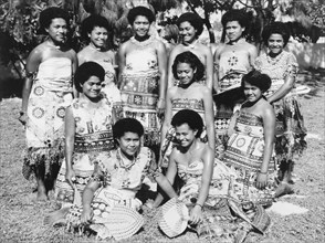 Fijian women wearing 'masi' cloth. A group of Fijian women pose for a portrait, wearing printed