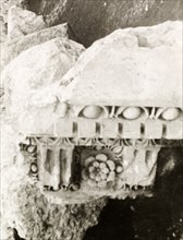 A carving amidst the ruins. A fragment of a carved stone capital lies amidst the Roman ruins at