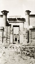 Mortuary Temple of Ramesses III. Two stone pillars stand either side of a gateway decorated with