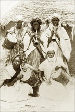Hausa musical band. Five Hausa musicians pose for a group portrait with their instruments. Two men