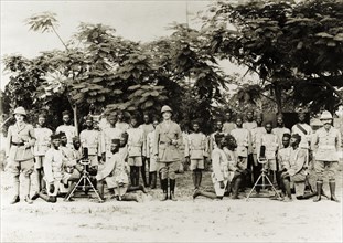 Artillery company of the Nigeria Regiment. Three British officers pose with an artillery company of