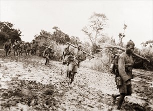 African schutztruppes on the march. A regiment of African schutztruppes trek across boggy land,