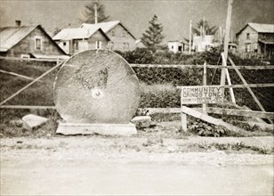 The Russian 'Community Grindstone' at Sitka . A large grindstone stands upright beside a road in
