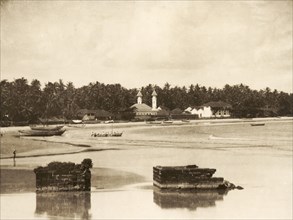 Madayi Mosque in Kannur. View across a sandy bay looking towards Madayi Mosque. The white marble