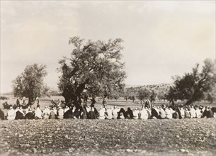 Police questioning Palestinian Arabs, 1938. A long line of Palestinian Arab villagers sit on the