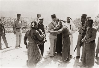 Police questioning Palestinian Arabs, 1938. Armed officers of the Palestine Police Force question a