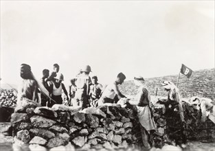 Building a camp at Kafr Ra'i. A group of Arab men construct a stone wall under British military
