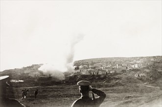 Mortar attack on a Palestinian village. British military officers look on as their mortar shell