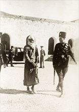 Arab prisoner led to court martial. A British police officer escorts a young Arab prisoner to court