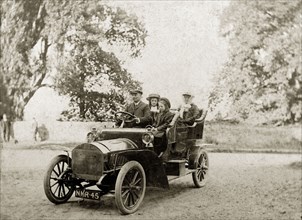Edwardian family in a motorcar. A British family, dressed in their best attire, drive a motorcar