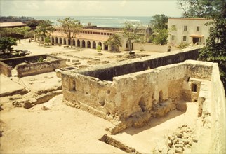 A courtyard inside Fort Jesus. Crumbling stone walls and foundations criss-cross a courtyard inside