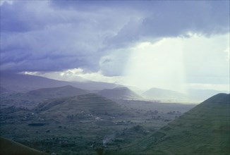 Storm over the Virunga Mountains. A shaft of light streams down between storm clouds over the