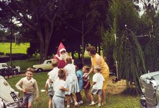 Meeting Father Christmas at Mbarara. A group of European children queue eagerly to meet Father