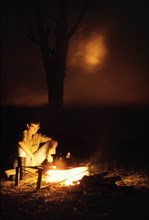 Camp fire at Ishasha River Camp. Elisabeth, the wife of District Forest Officer James Lang Brown,