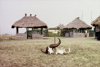 Entrance to Ishasha River Camp. A sign decorated with buffalo and hippo skulls marks the entrance