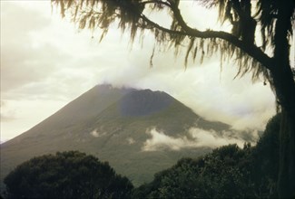 Clouds over Mount Muhabura. Heavy clouds hang over Mount Muhabura (Muhavura), an extinct volcano in