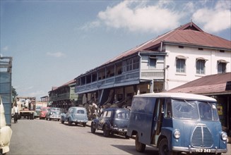 Kampala bazaar. Kampala Road with parked cars in the bazaar. Kampala, Uganda, 1960. Kampala,