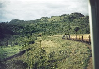 Through the Aberdare Mountains'. A train winds its way through the Aberdare Mountains on the Uganda