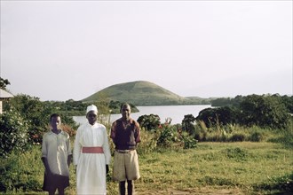 Portrait of three Ugandan house staff. Three Ugandan house staff on the shores of a lake. They are