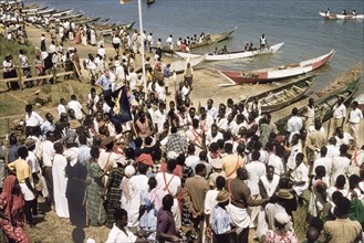 Regatta celebrating the Kabaka's return. Crowds gather on the banks of Lake Victoria to watch a