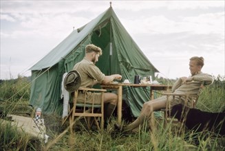 Breakfast on safari'. District Forest Officer James Lang Brown (left) enjoys breakfast with a