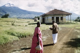 A Gombolola chief and his wife. A Gombolola chief and his wife walk towards his office below Mount