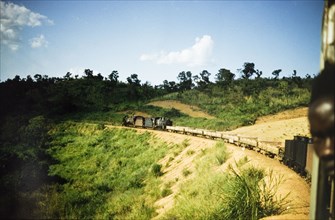 Freight cars on the Western Ugandan Extension. A steam locomotive pulls a line of freight cars